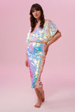 Front view of a dark haired woman wearing a Rosa Bloom Opal white sequin mid length sequin tube skirt