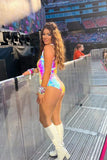 Smiling brown haired girl at a Taylor Swift concert posing in front of the stage wearing knee high white boots and a Rosa Bloom iridescent Opal Sequin Fifi Leotard