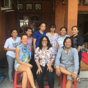 Rosa and Annie with some of her staff sitting together in front of a building