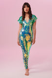 Dark haired model with long hair wearing a Rosa Bloom sequin Aphrodite jumpsuit in Chameleon