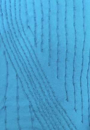 Close-up of blue fabric showing hand-embroidered stitches