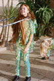 Children in a brightly lit outdoor space playing a playground game of hula hoop! They are wearing Rosa Bloom chameleon mint green, shimmering sequin leggings for children with matching chameleon sequin t-shirt for children.