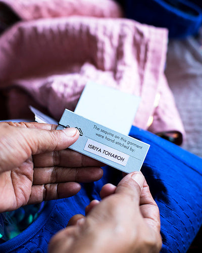Hands holding a name tag with text on it against a colorful background