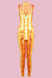 An all-in-one sequin stretchy festival jumpsuit with a high neck, made with large round holographic Rosa Bloom sequins. The Fox jumpsuit in front of a pink background, glistens all over in this colour way, creating a mix of shimmering sequin colours of gold and yellow that sparkles in the light.
