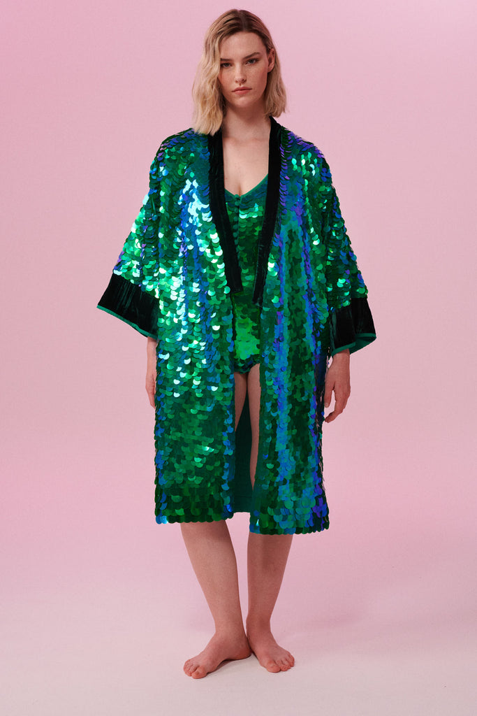 Blonde haired model wearing a Rosa Bloom Emerald Sequin Robe