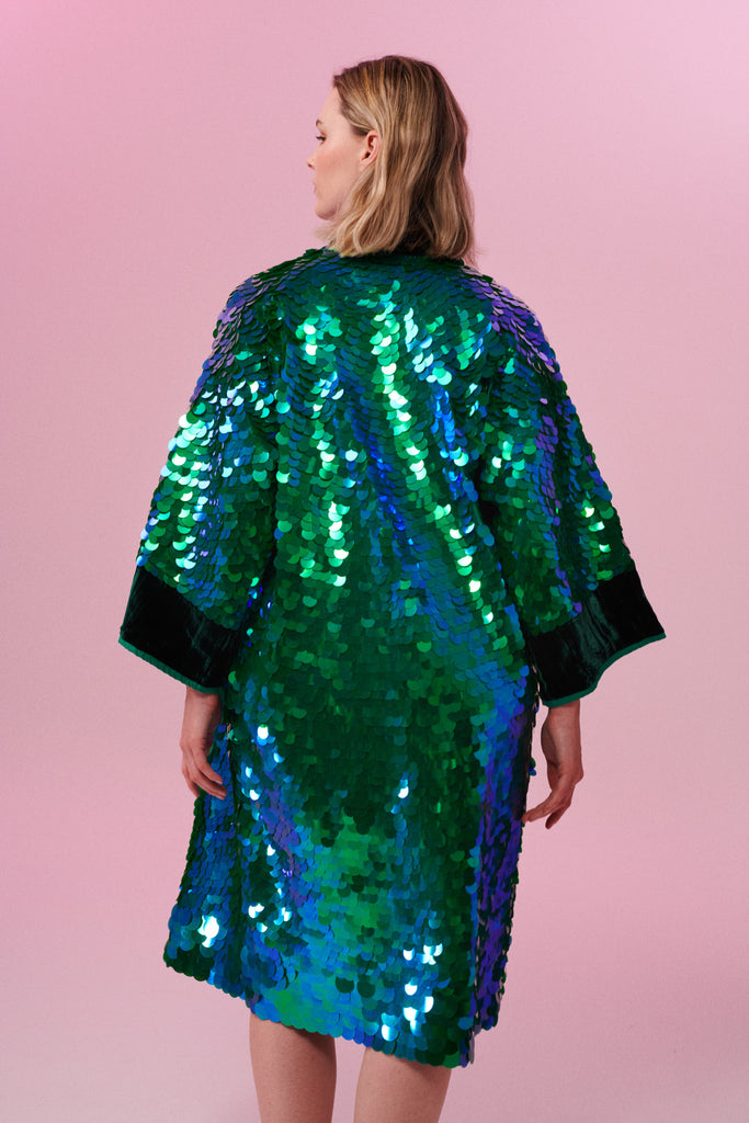 Blonde haired model wearing a Rosa Bloom Emerald Sequin Robe