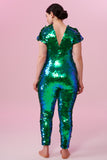 Dark haired model posing in a Rosa Bloom Aphrodite sequin jumpsuit in Emerald green