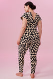 Dark haired model with hair tied back wearing a Geometric black and white tri-print organic cotton jumpsuit