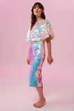 Side view of a dark haired woman wearing a Rosa Bloom Opal white sequin mid length sequin tube skirt