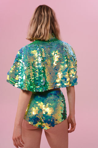Rear view of a woman wearing Rosa Bloom Shimmering Sequin Cape with light green sequins