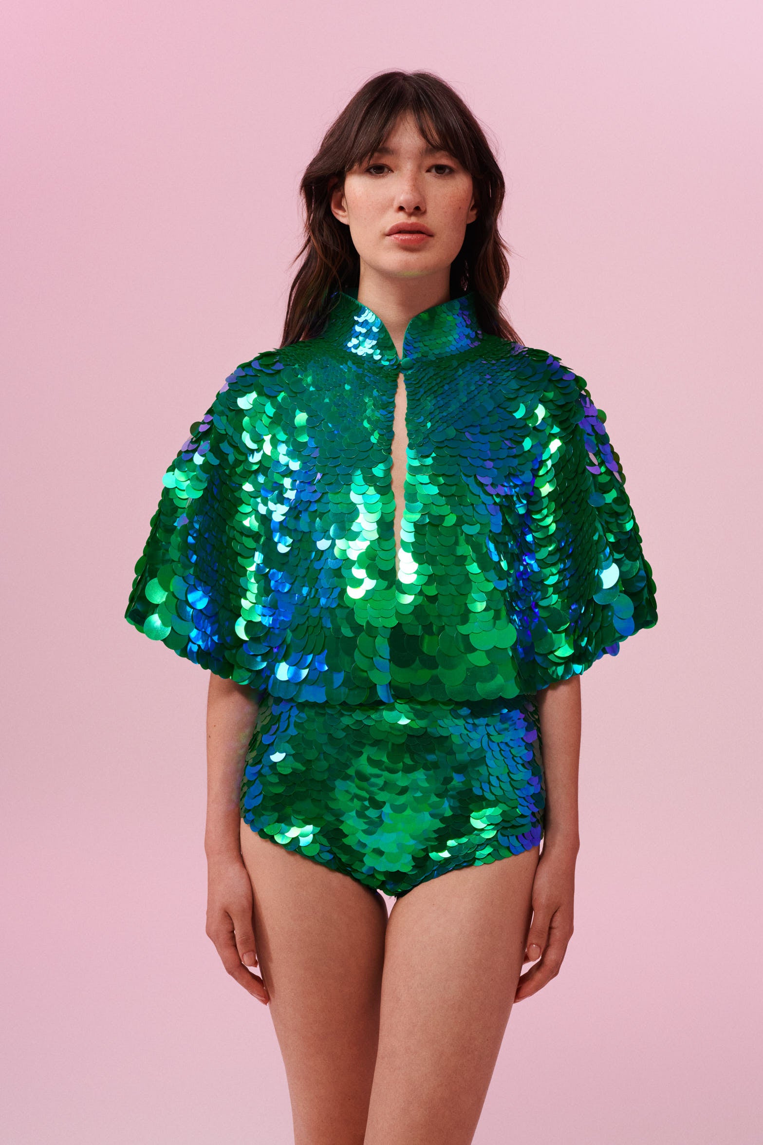 Front view of a woman wearing Rosa Bloom Shimmering Sequin Cape with Emerald green sequins