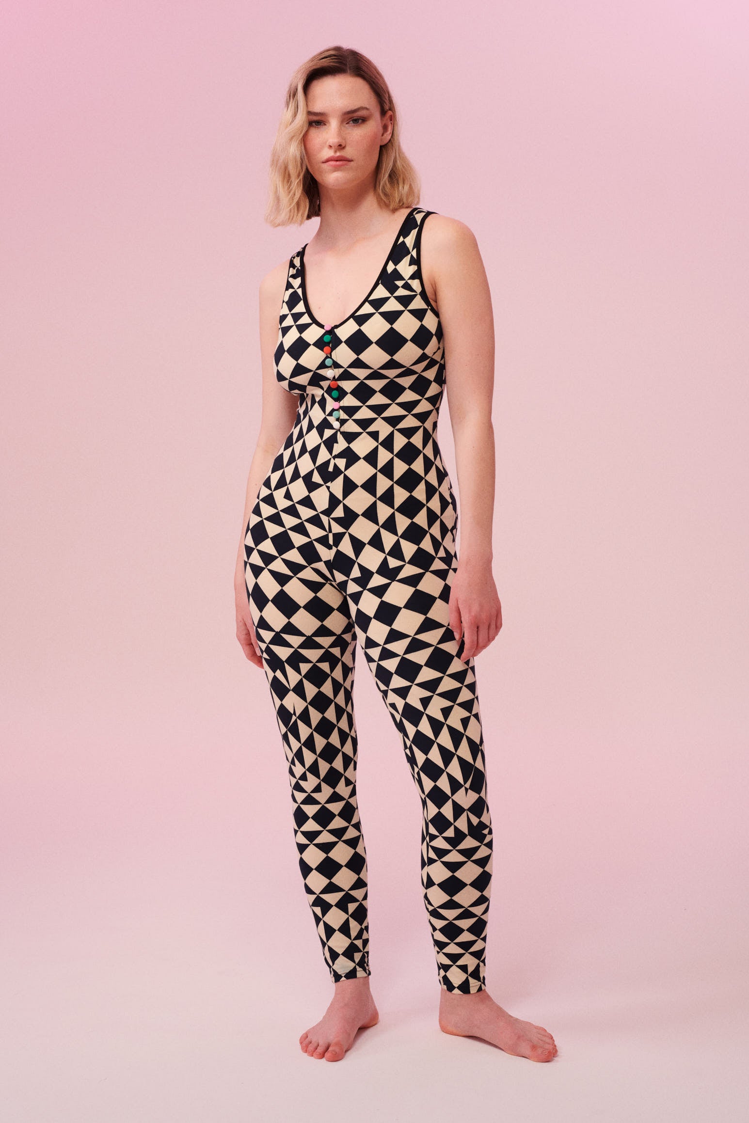 Front view of a woman wearing a triangular print black and white Rosa Bloom jumpsuit