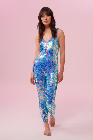 Front view of a woman wearing blue and pink sequin Rosa Bloom jumpsuit