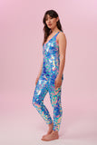 Side view of a woman wearing blue and pink sequin Rosa Bloom jumpsuit