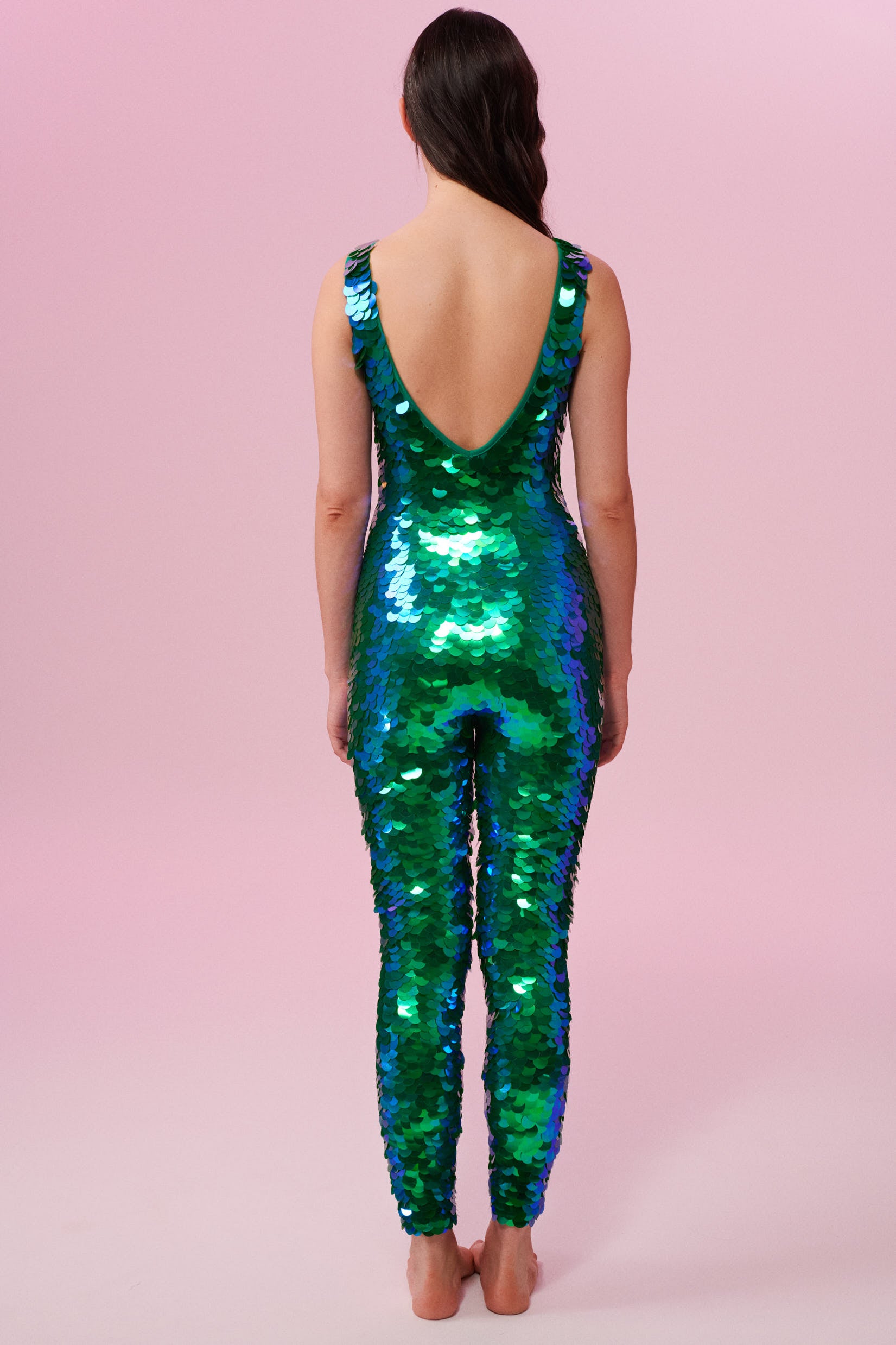 Rear view of a woman wearing an emerald sequin Rosa Bloom jumpsuit