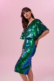 Model with long brown straight hair posing front on wearing an emerald green Rosa Bloom Georgie sequin skirt and a Rosa Bloom Emerald green sequin cape top