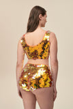 Rear view of a woman wearing stretchy Rosa Bloom Gigi hotpants with large sparkling orange sequins 